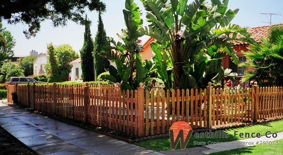 Pointed redwood picket fence with post caps